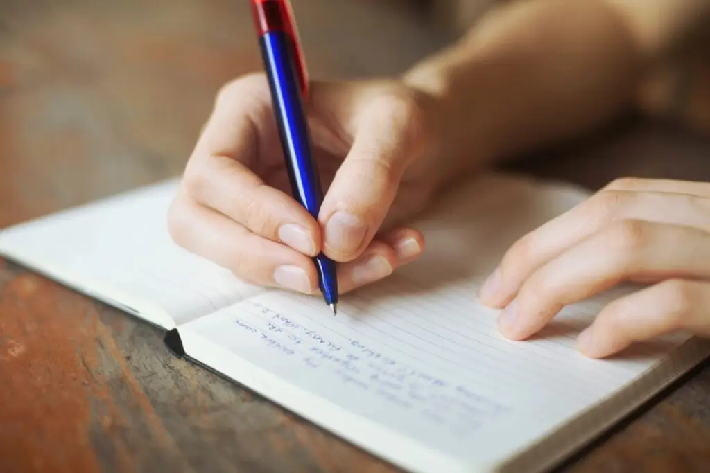 Planning a move with a notebook and pen, outlining a structured plan for relocation.